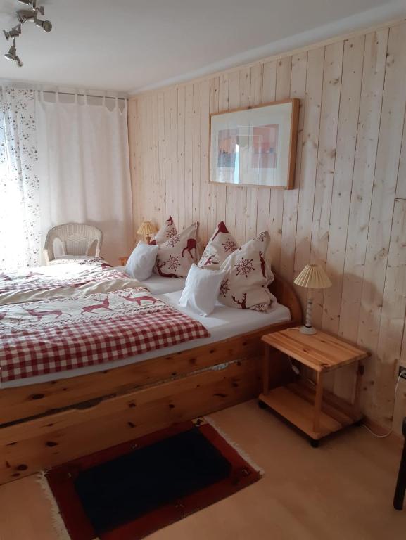 Schlafzimmer mit einem Holzbett und einem Tisch in der Unterkunft Haus Mauken - Appartments mit Panoramablick in Murau