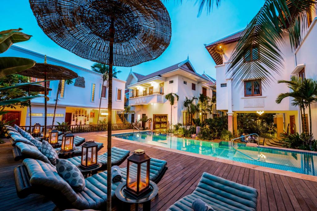 a villa with a swimming pool and a resort at Mane Boutique Hotel & Spa in Siem Reap