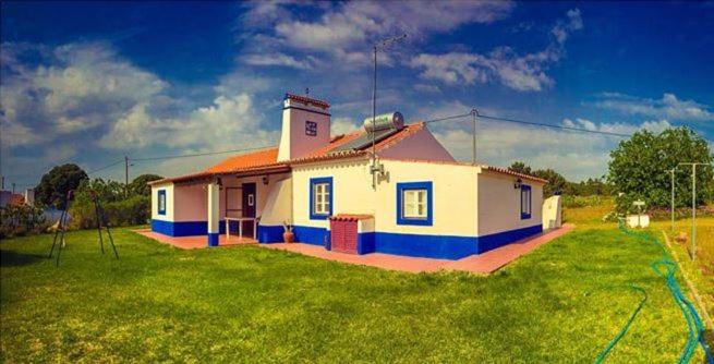 a small house on a grassy field with afficient at Monte da Linda, 5 mins from Melides beach in Melides