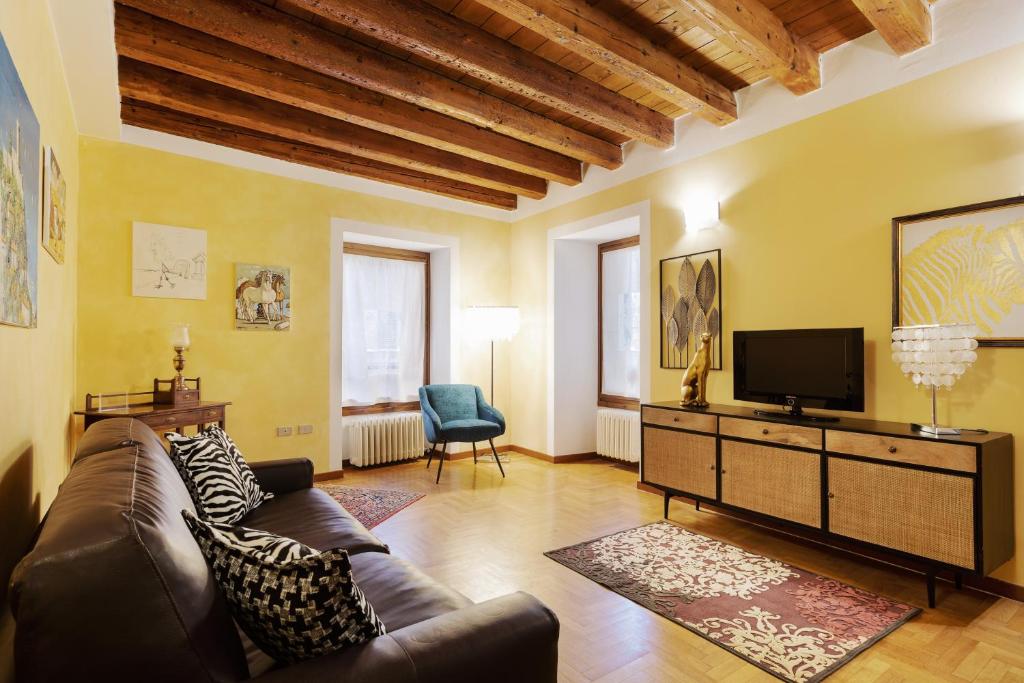 a living room with a couch and a tv at Città Antica Charming Flat in Verona