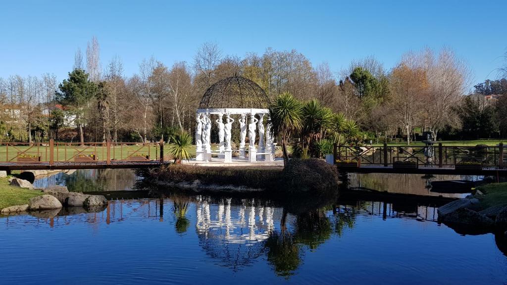 einen Brunnen inmitten eines Teiches mit einer Brücke in der Unterkunft Quinta dos Jasmins in Paços de Ferreira