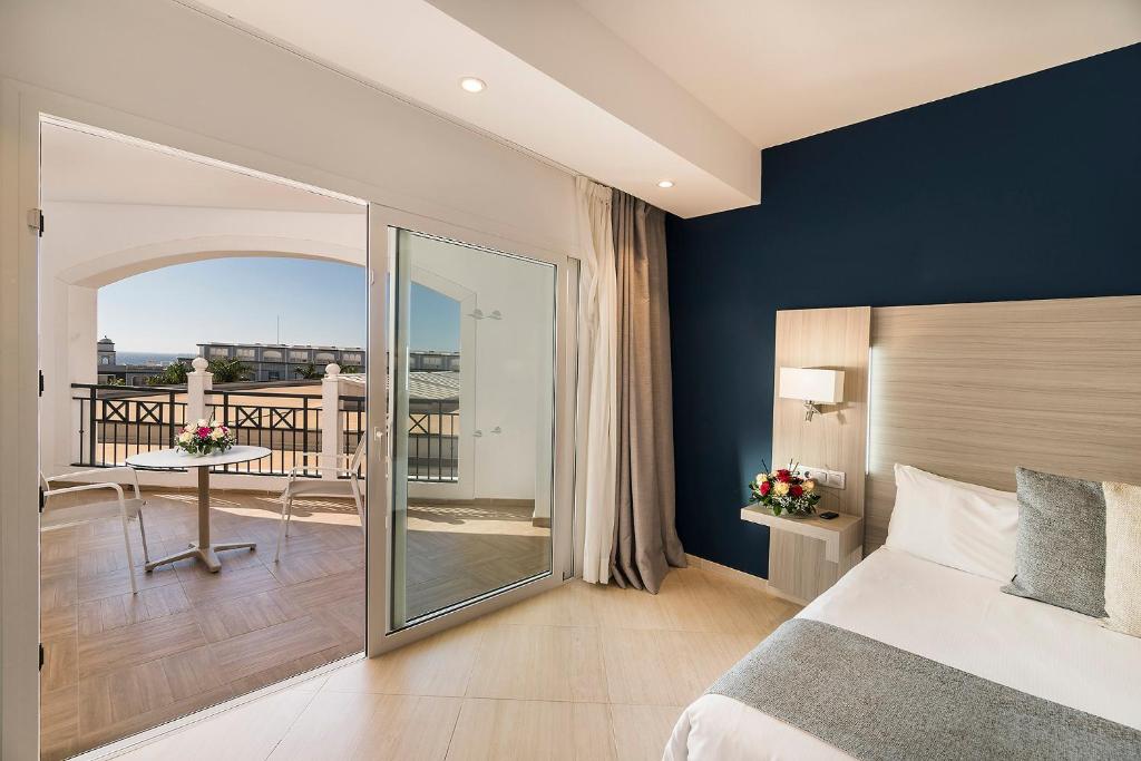 a bedroom with a large bed and a balcony at Royal Palm Resort & Spa - Adults Only in Playa Jandia