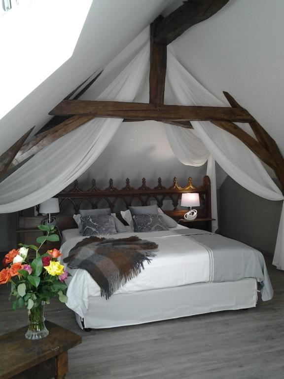 a bedroom with a white bed with a canopy at Le Manoir des Roches in Bourré