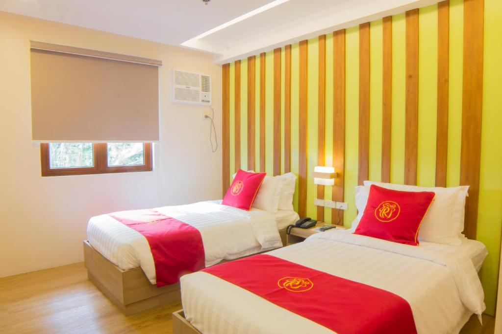 dwa łóżka w pokoju z żółtymi i czerwonymi paskami w obiekcie Hotel Rosita w mieście Lucena