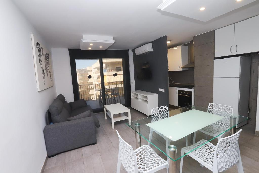 a kitchen and living room with a glass table and chairs at DIFFERENTFLATS Grd in Salou