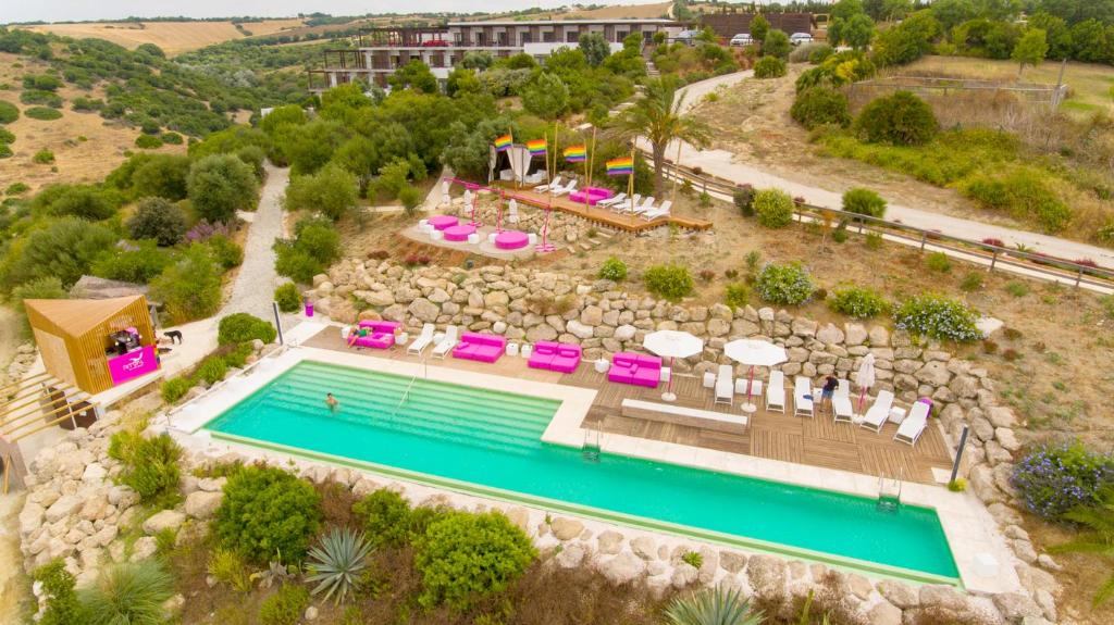 uma vista aérea de uma piscina de resort com cadeiras e mesas em Hotel Ritual El Palmar-Adults Only em Vejer de la Frontera