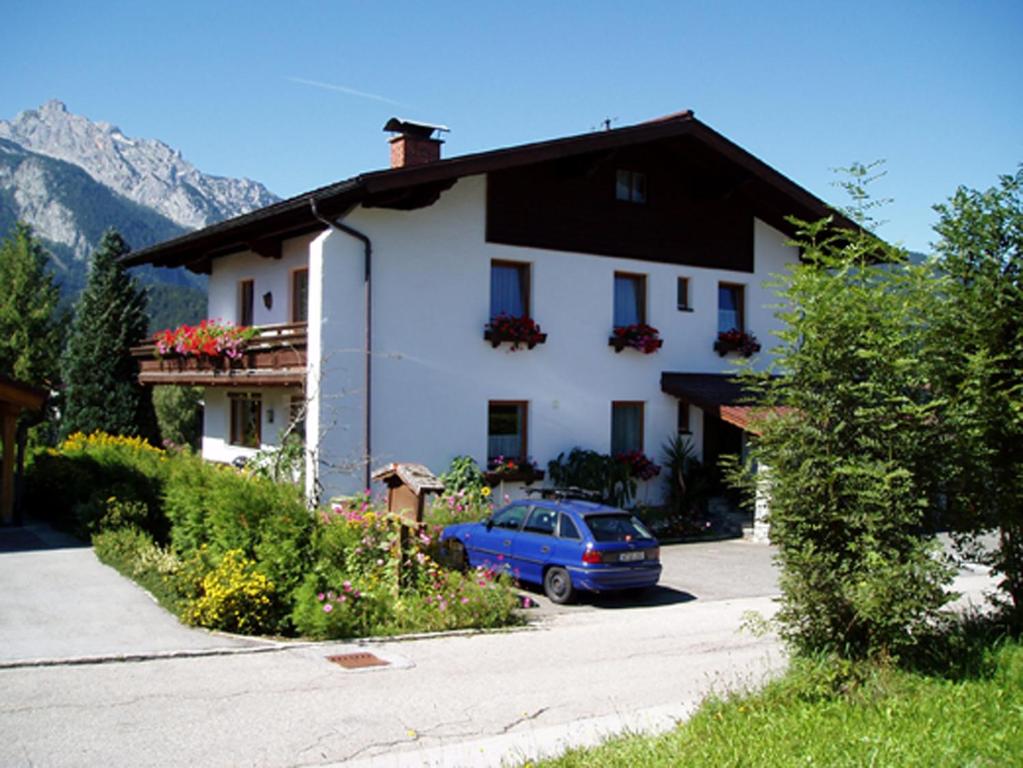 een huis met een blauwe auto die ervoor geparkeerd staat bij Haus Bergheimat in Abtenau
