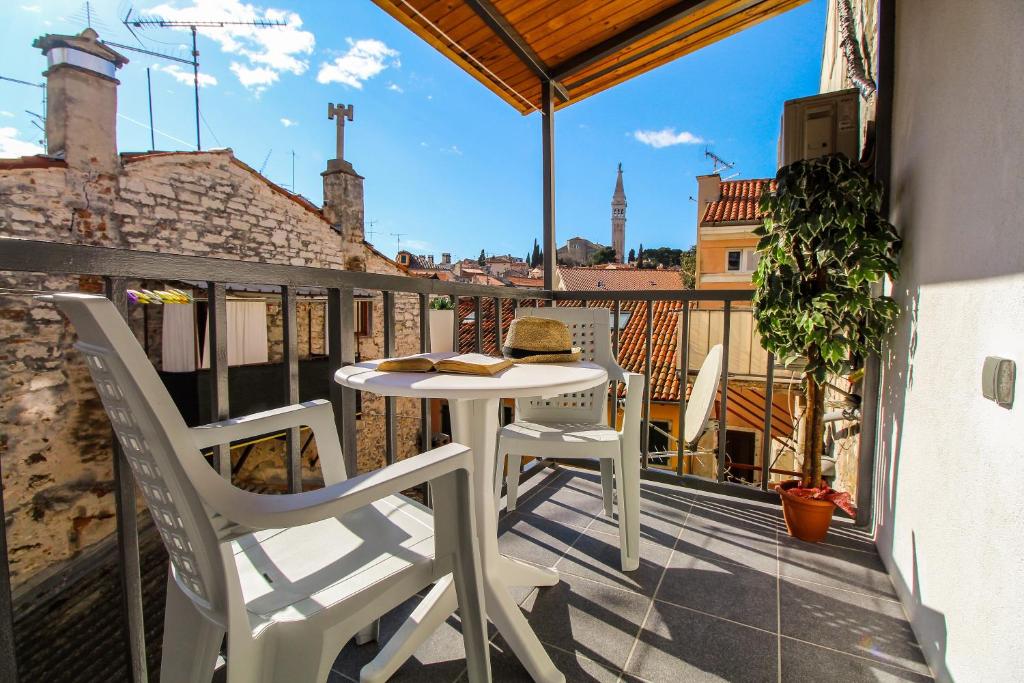 a balcony with a table and chairs on a balcony at Apartment Orkić in Rovinj