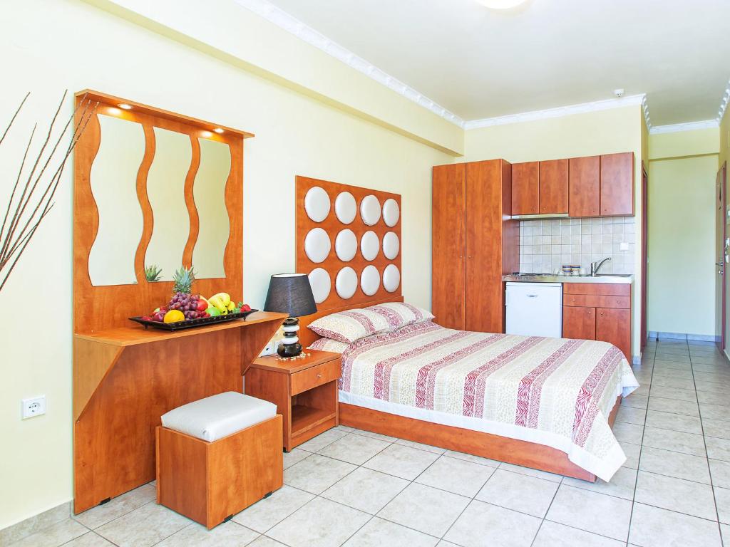 a bedroom with a bed and a table with a bowl of fruit at Casa Di Mare in Olympiaki Akti