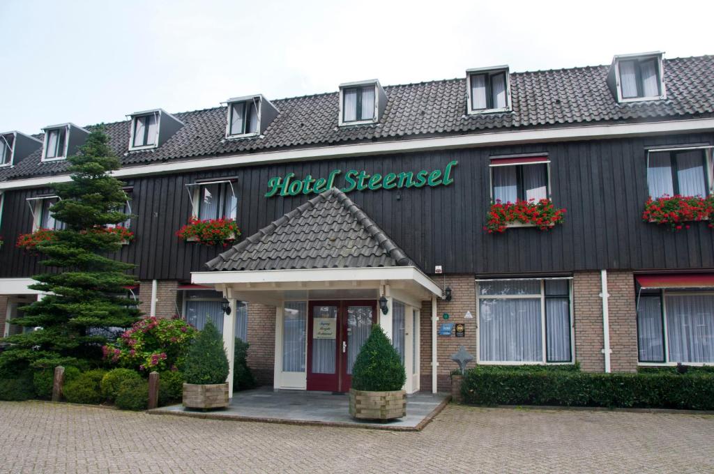 een gebouw met een bord dat het hotel stuurt bij Hotel Steensel in Steensel