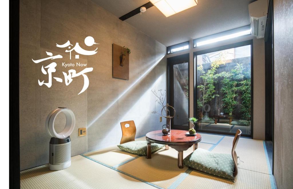 een kamer met een tafel en stoelen en een raam bij Kyomachi Hoshizuki in Kyoto
