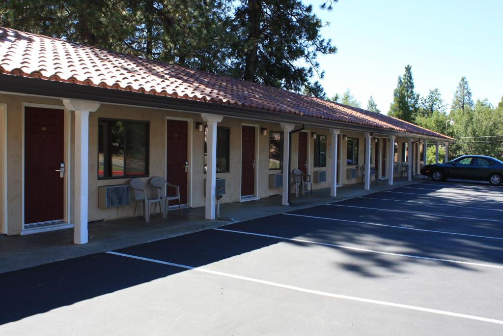 a building with a car parked in a parking lot at Gold Trail Motor Lodge in Placerville