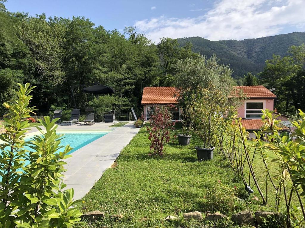 a garden with a swimming pool and a house at VILLA DELLE ROSE CINQUE TERRE in Beverino