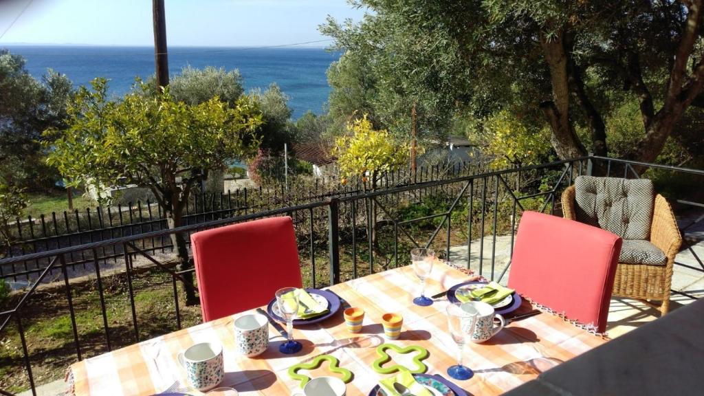 uma mesa com cadeiras vermelhas e uma mesa com comida em Gerakina beach cottage em Psakoudia