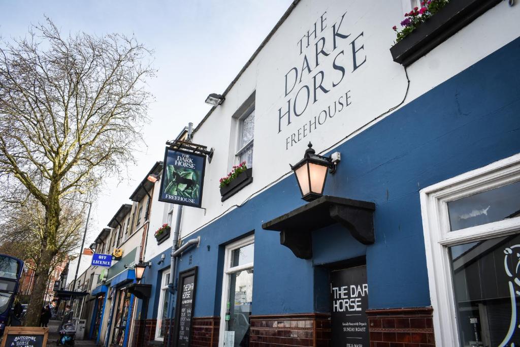 um edifício azul com um sinal na lateral em The Dark Horse em Bristol