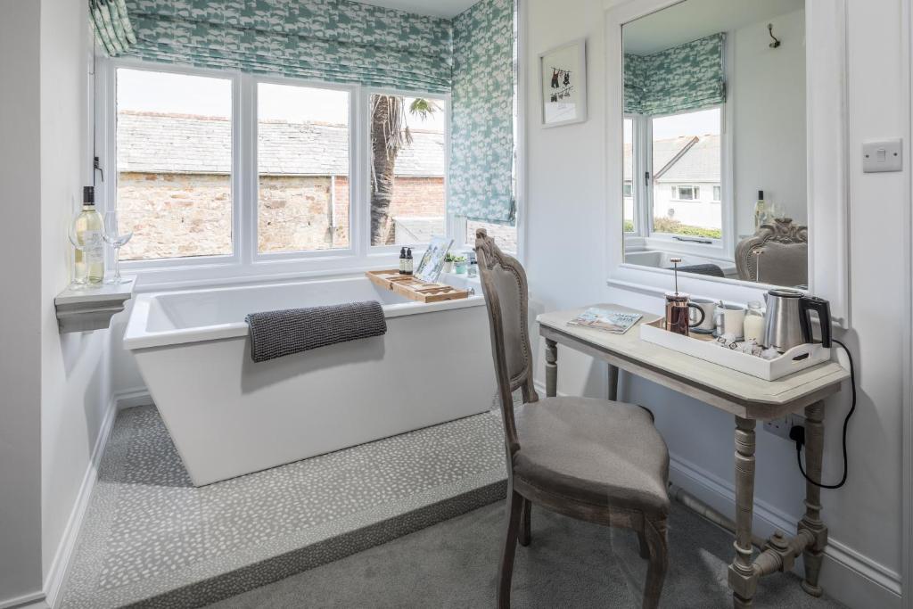 a bathroom with a tub and a desk and a sink at Penwyth House in Newquay