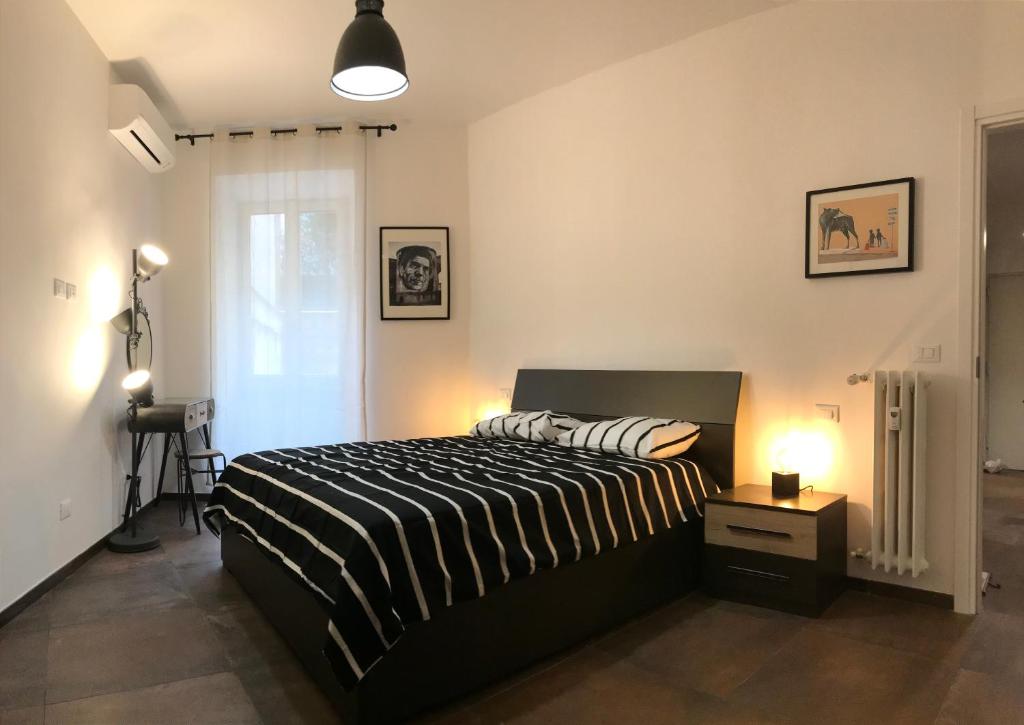 sypialnia z czarno-białym łóżkiem i oknem w obiekcie Appartamento in via Licia w Rzymie