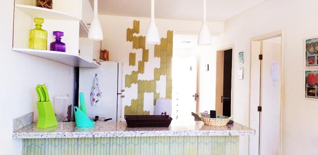 a kitchen with a counter with colorful vases on it at Ap aluguel no Guaibim in Guaibim