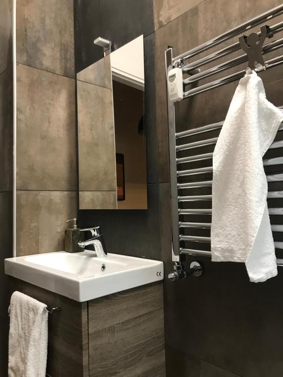łazienka z białą umywalką i lustrem w obiekcie Appartamento in via Licia w Rzymie