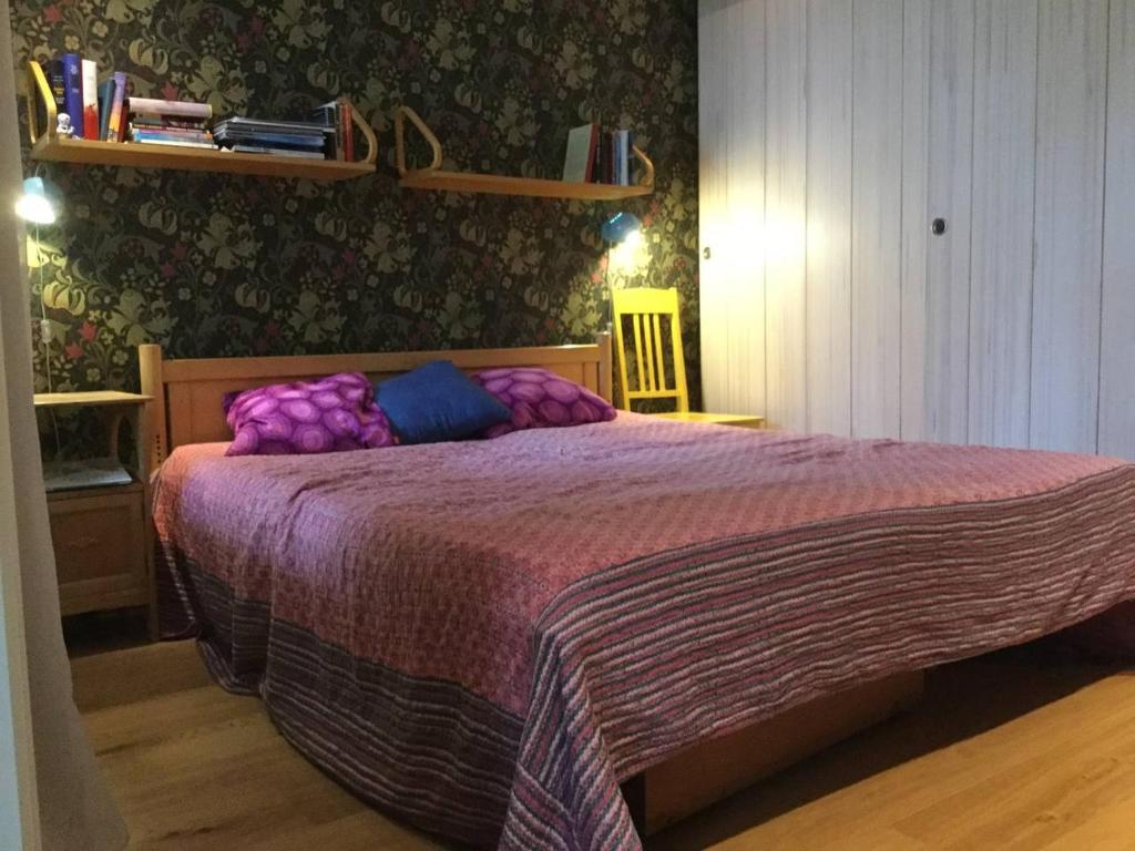 a bedroom with a large bed with a purple blanket at Jeja Roosintie 6 in Hanko