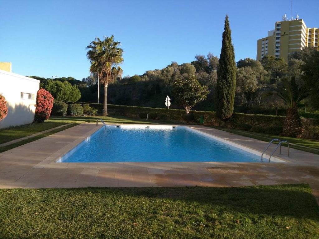 a swimming pool in the middle of a yard at Casa da Praia Apartment - Alvor Beach in Alvor