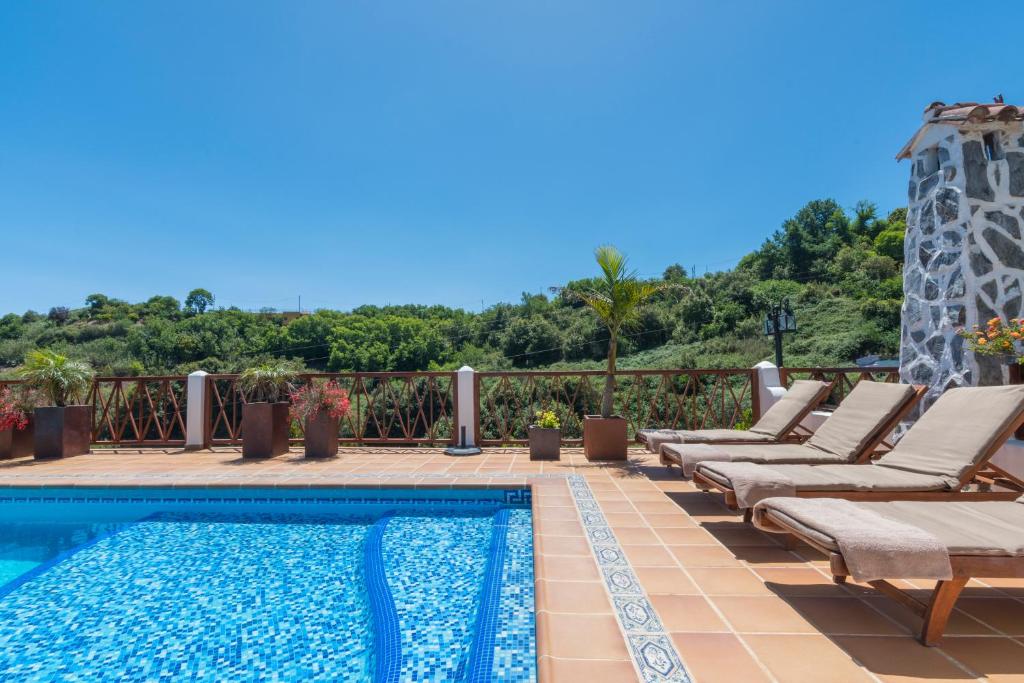 un patio con tumbonas y una piscina en Finca Casas Nanitas, en Moya