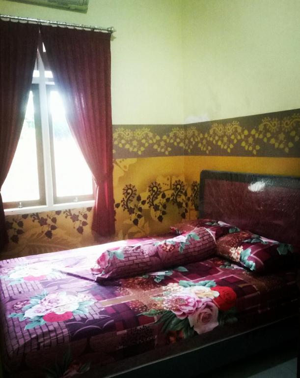 a bedroom with a bed with pillows on it at Nakula's Guest House in Banyuwangi