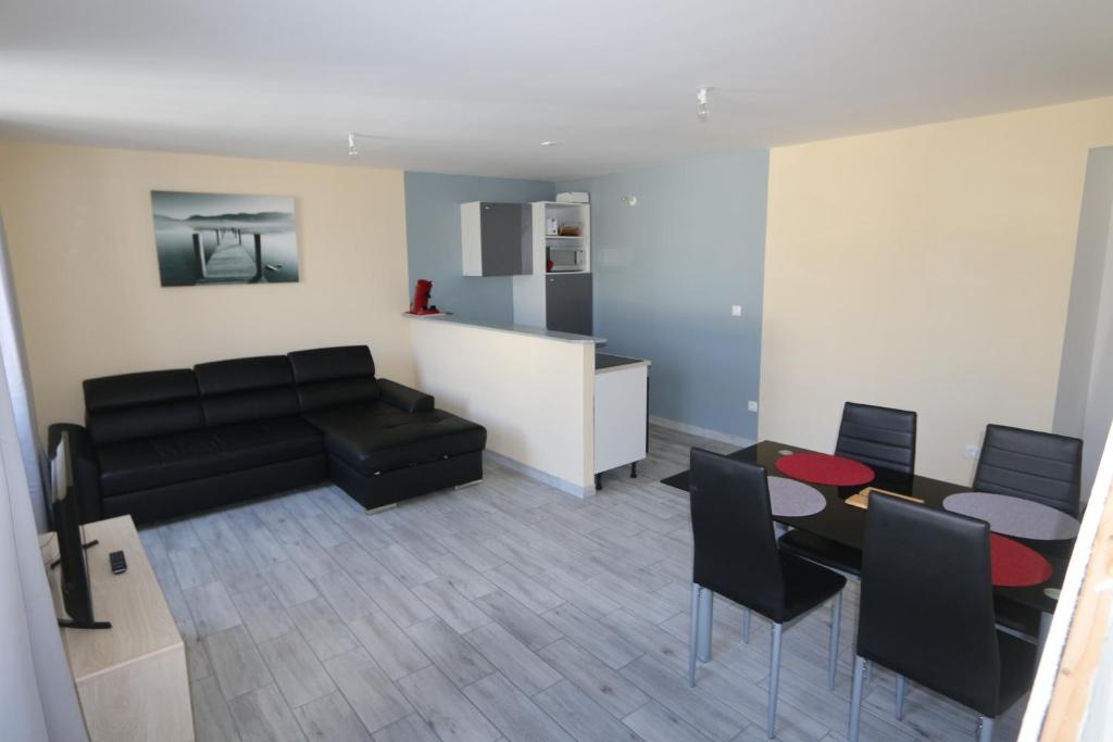 a living room with a couch and a table and chairs at Apparts Gites Cholet centre in Cholet