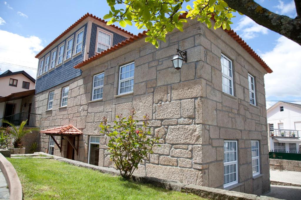 - un grand bâtiment en pierre avec une fenêtre dans l'établissement Cerrado dos Outeirinhos, à Cinfães