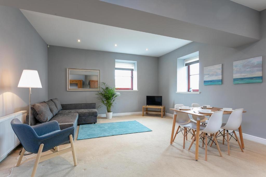 uma sala de estar com uma mesa e um sofá em Granary Suite No3 - Donnini Apartments em Ayr