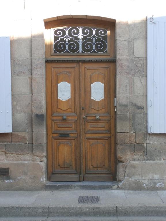 a wooden door on a building with a gate at La Maison XVIIIe in Moulins