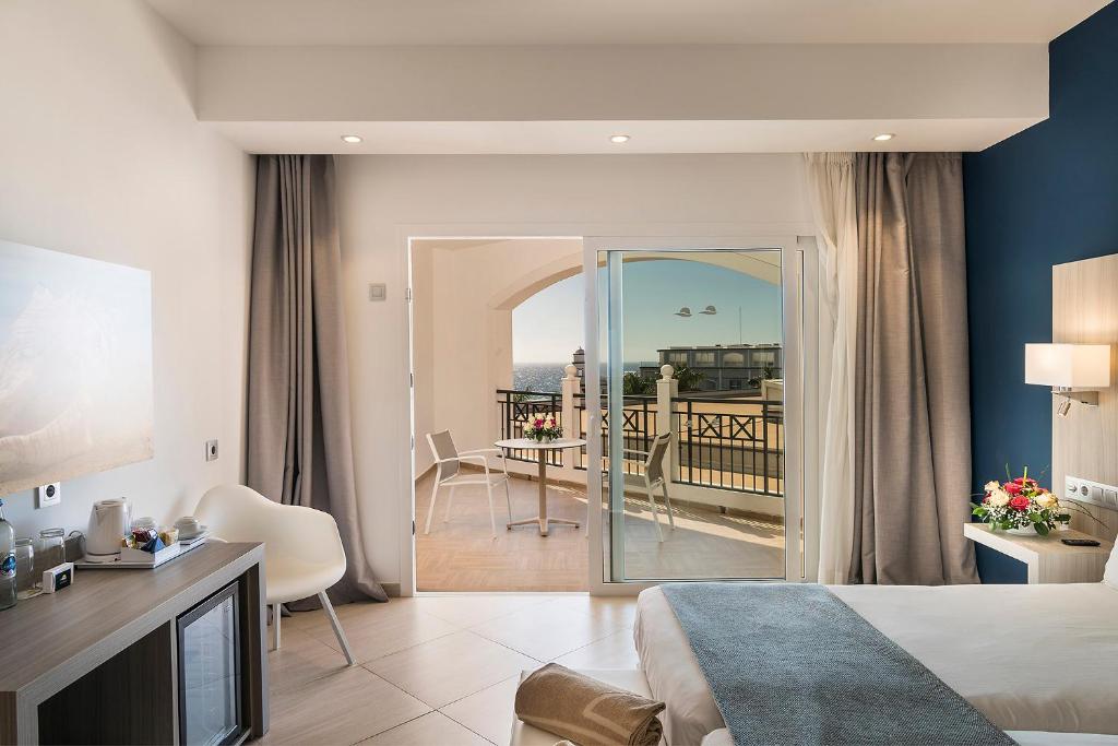 a hotel room with a bed and a balcony at Royal Palm Resort & Spa - Adults Only in Playa Jandia