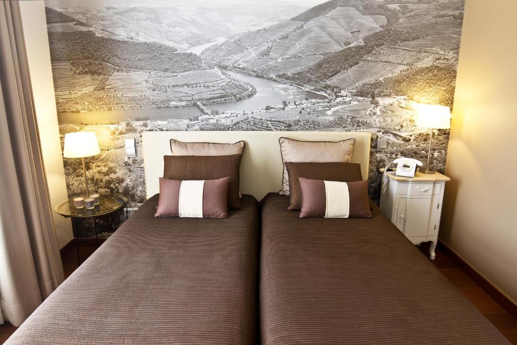 
a hotel room with a bed and two lamps at Ribeira do Porto Hotel in Porto
