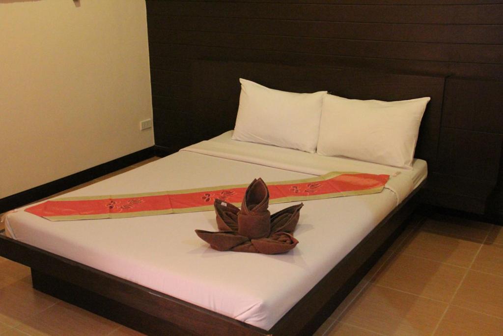 a bed with a flower on top of it at Baan Vor. Sumongkol Service Apartment in Khon Kaen