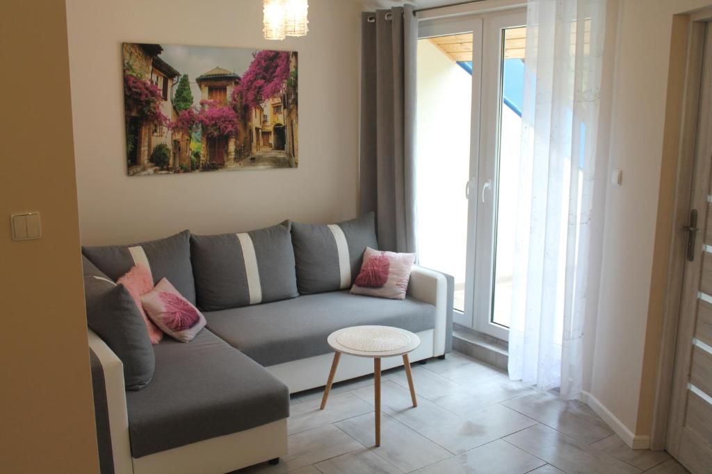 a living room with a couch and a table at Apartament "Zacisze" in Łukęcin