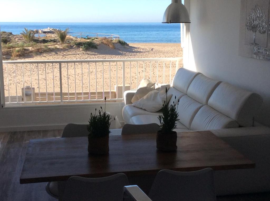 uma sala de estar com um sofá e uma mesa e a praia em Martí em Calpe