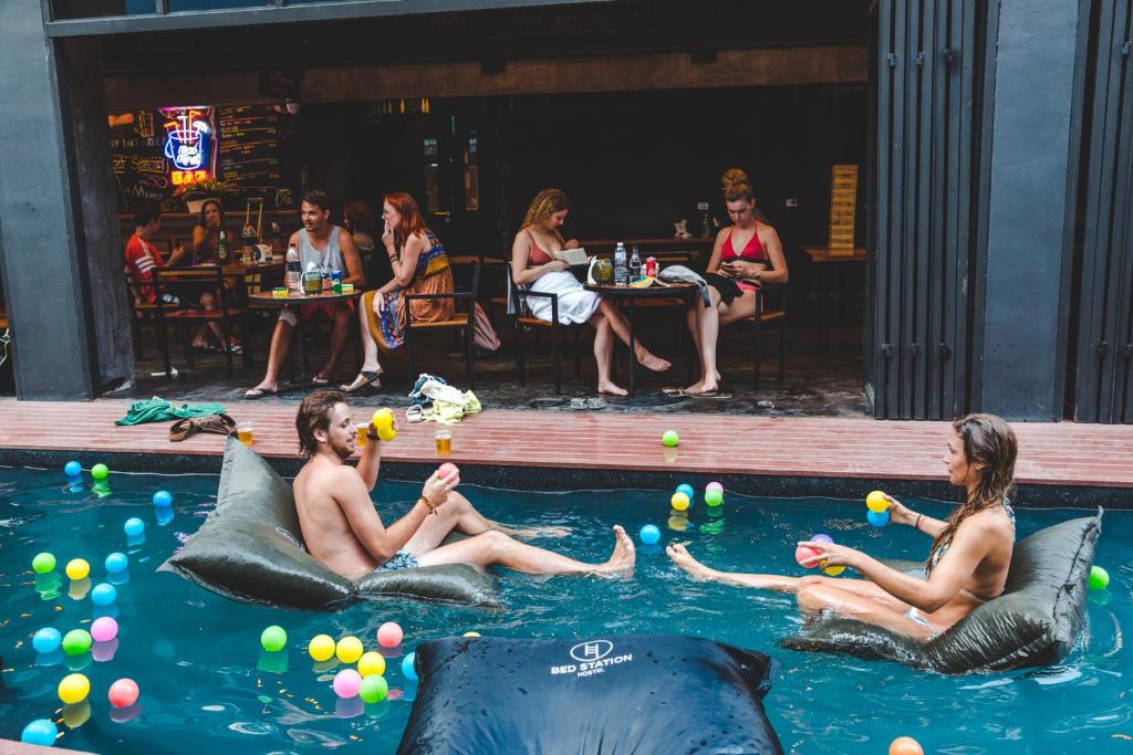 a group of people sitting in the water with dolphins at BED STATION Hostel Khaosan in Bangkok