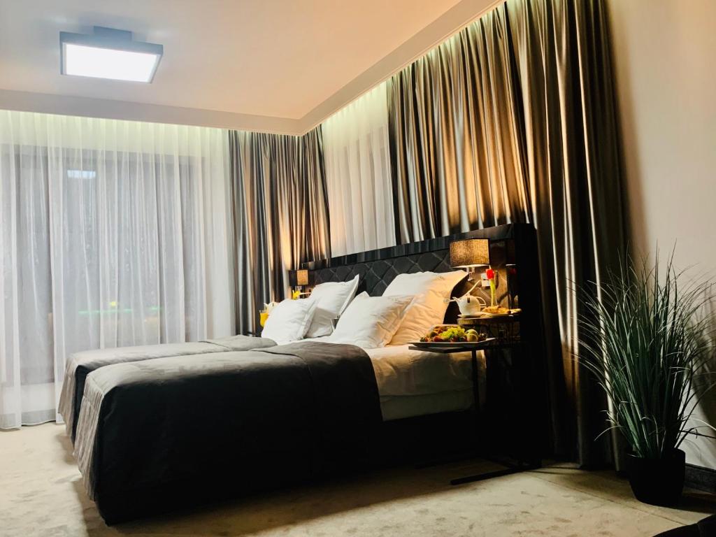 a bedroom with a large bed in front of a window at Hotel Fado in Gorzów Wielkopolski