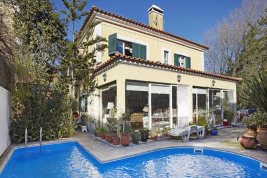 a large house with a swimming pool in front of it at At Home Sintra in Sintra