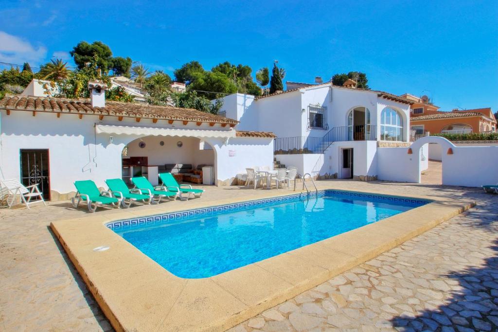 eine Villa mit einem Swimmingpool vor einem Haus in der Unterkunft Mabruka - charming, Finca style holiday villa in Benissa in Benissa
