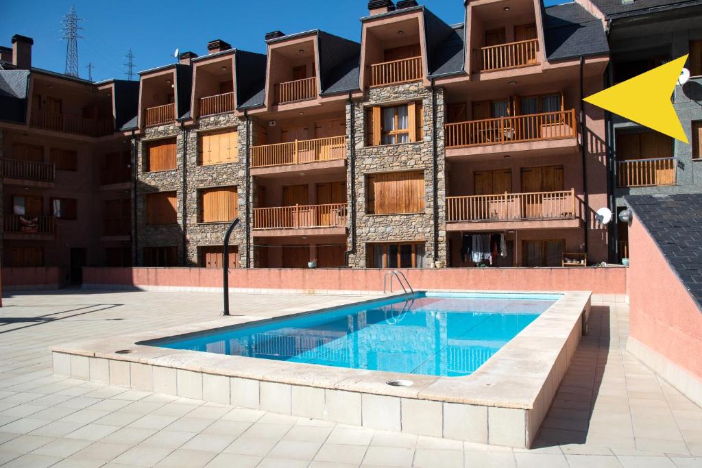 a swimming pool in front of a building at Apartamento CA L'ANTON con Parking in Rialp