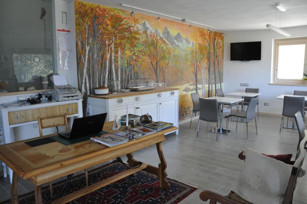 Zimmer mit einem Tisch und einem Laptop darauf in der Unterkunft Affittacamere Rubino Guest House in Ponte nellʼAlpi