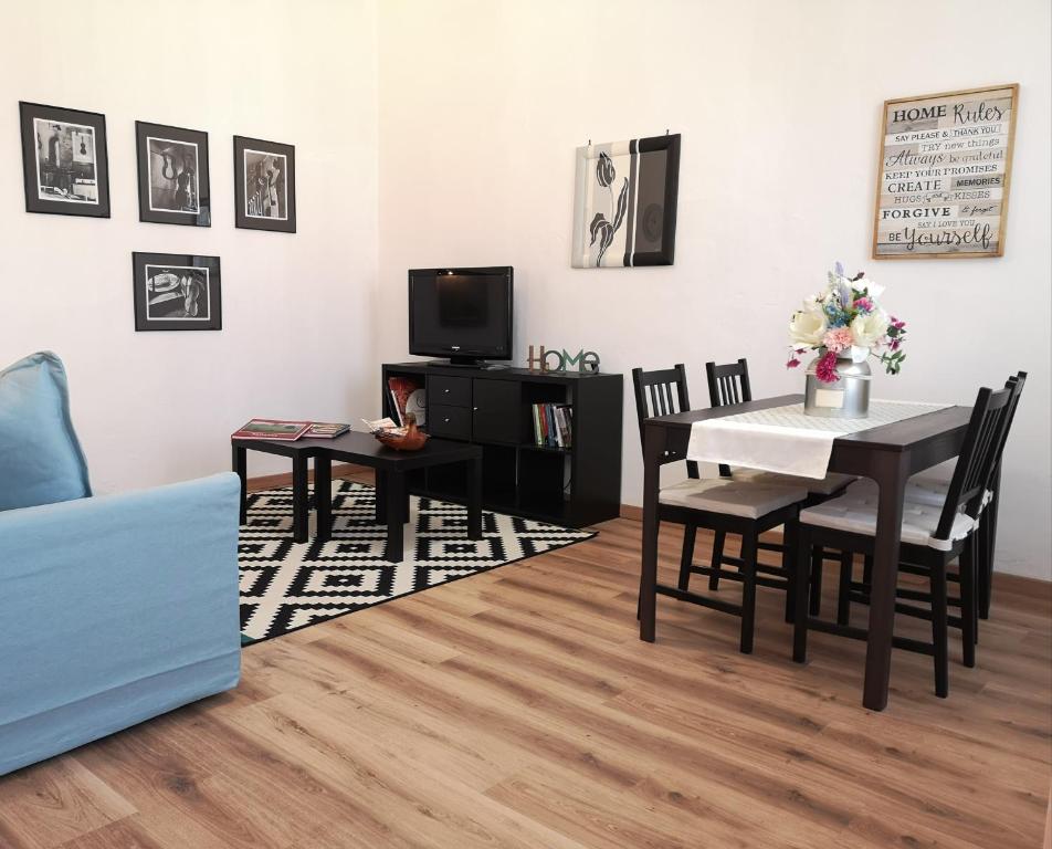 a living room with a table and chairs and a tv at AT HOME IN CREMONA in Cremona