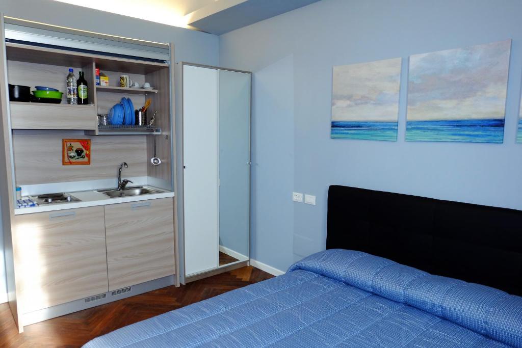 - une chambre avec un lit bleu et un lavabo dans l'établissement MONOLOCALE VICINO MILANO 2, à Lodi