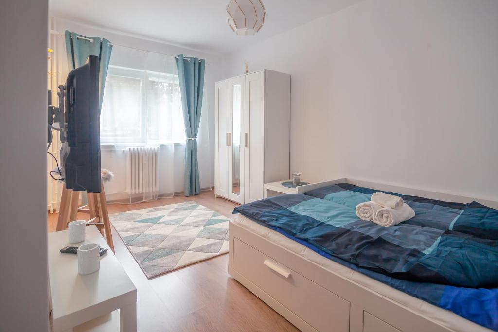 クルジュ・ナポカにあるInternational Aparthotelのベッドルーム1室(青いシーツと鏡付きのベッド1台付)