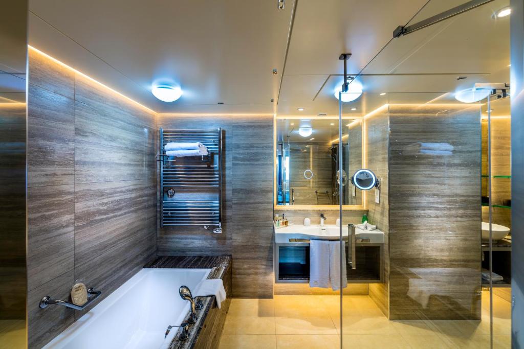 a bathroom with a tub and a sink at Columbia Beach Resort in Pissouri