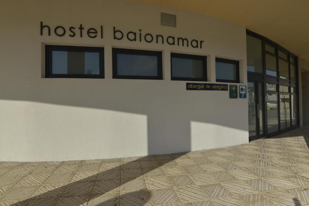 um edifício hospitalar com uma placa que lê batalhão de hostel em Hostel Albergue Baionamar em Baiona