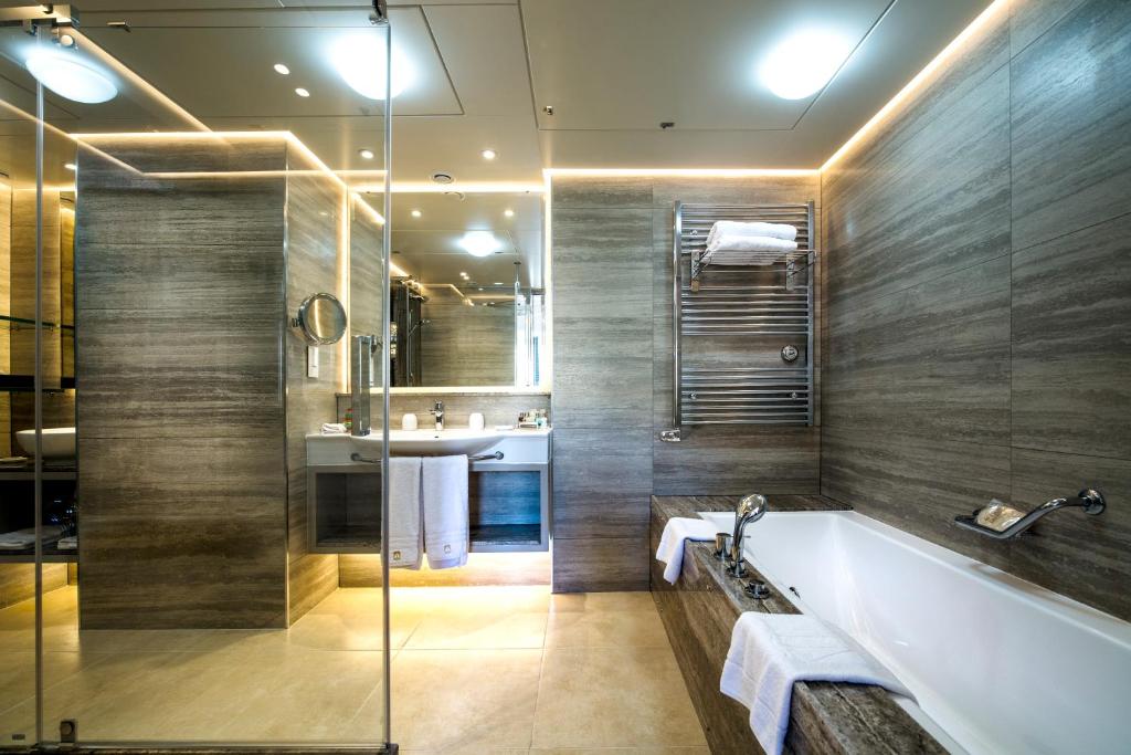 a bathroom with a tub and a sink at Columbia Beach Resort in Pissouri