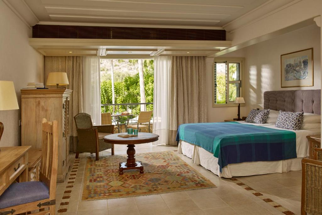 a hotel room with a bed and a table at Columbia Beach Resort in Pissouri