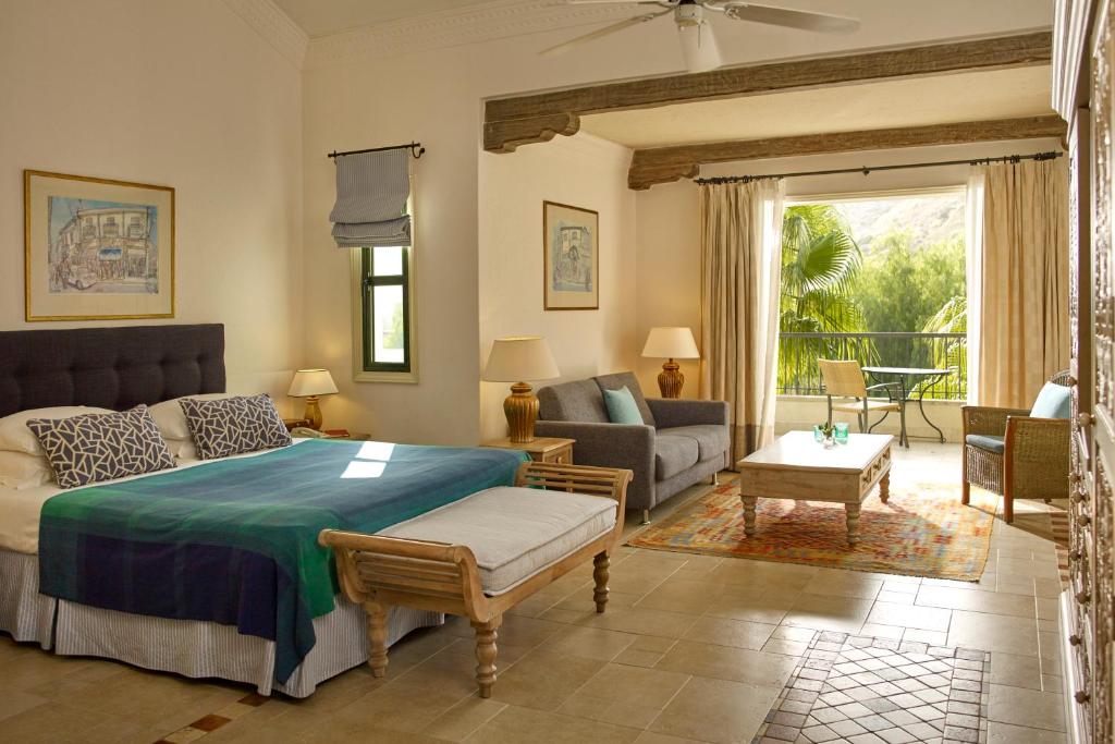a bedroom with a bed and a living room at Columbia Beach Resort in Pissouri